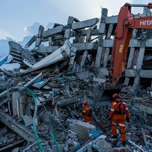 Aid workers working in a fallen building from an equake.